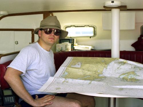 David checks the chart while sailing along the Maine Coast in July 1997