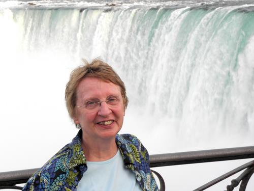 visitor standing before Horseshoe Falls at the main viewpoint on the Canadian side of Niagara Falls