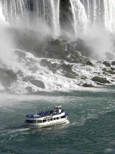 the Maid of the Mist cruises past the American Falls as seen from the Canadian side of Niagara Falls