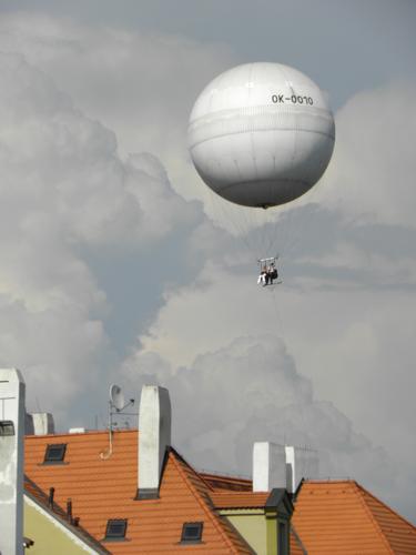 tourists afloat on a tethered hot-air balloon above Prague in the Czech Republic