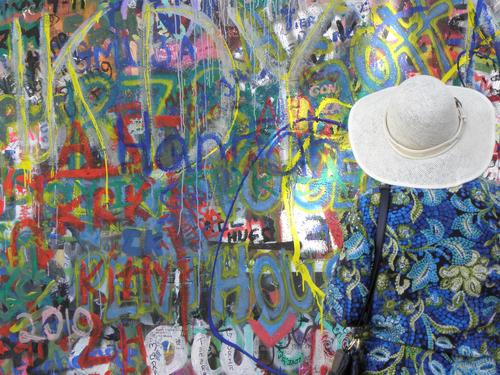 a tourist before the Lennon Peace Wall at Prague in the Czech Republic