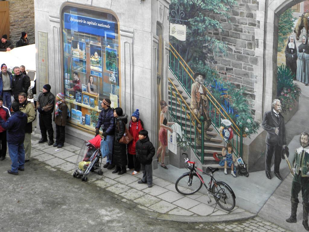 tourists watch the Ice Race before a clever 3D wall mural in Quebec City, Canada
