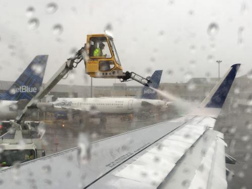 plane wing being de-iced in February at Logan Ariport in Boston before departure to San Diego