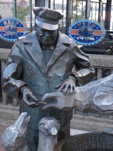 statue outside Ivars restaurant of the founder feeding seagulls at Seattle in Washington