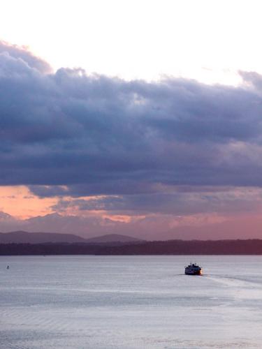 ferry sailing off into the sunset as seen from a harbor hotel at Seattle in Washington