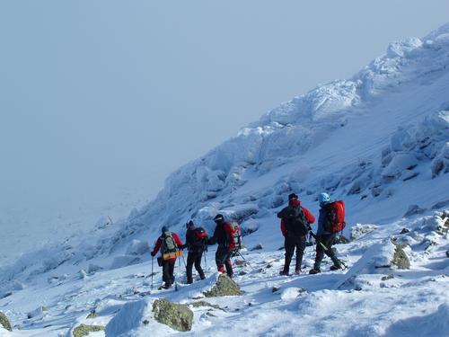 winter hikers head down from the summit of Mount Adams in New Hampshire into an undercast cloud layer