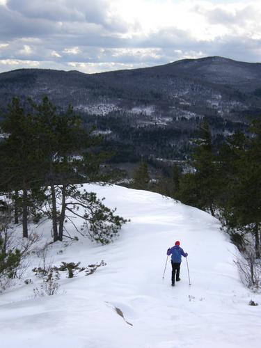 hiker on the trail down Bayle Mountain in New Hampshire