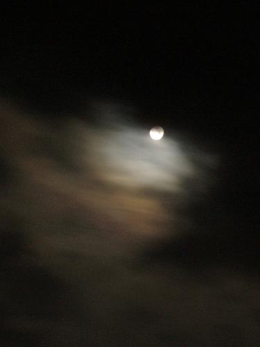 full moon peeking through fast-moving clouds on Bondcliff Mountain in New Hampshire