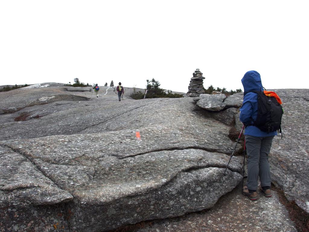 Andee looks ahead toward cairns and the summit firetower as we hike from the west to Mount Cardigan in New Hampshire