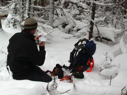 a bushwhacker checks the canister log atop Round Mountain in Vermont