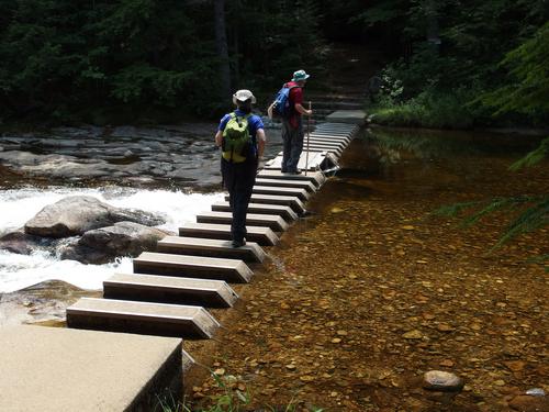 John and Elaine cross Cold River on a cool piano-keyboard-bridge on the hike down from Deer Hill in western Maine