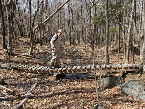 Dick walks a mountain-bike bridge on the way up to Page Hill in New Hampshire