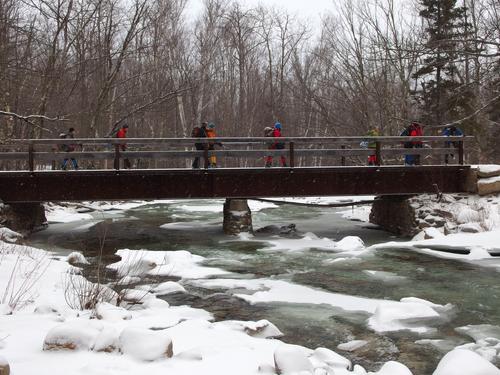 winter hikers crossing Little River on the way to Mount Hale in New Hampshire