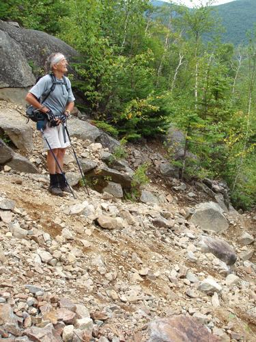 hiker on the slide path to Owl's Head in New Hampshire