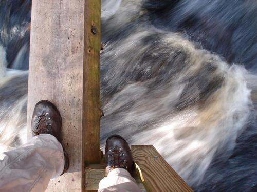 feet on the way across the upper bridge in Purgatory Falls Brook Preserve in New Hampshire