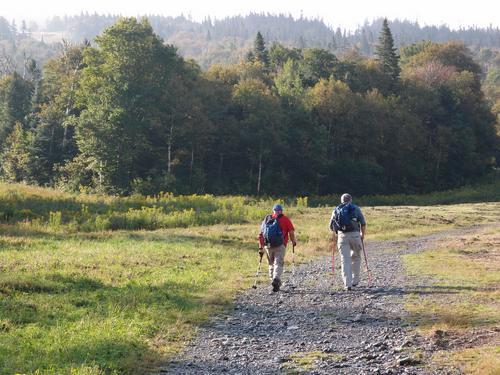 hikers starting up the ski trail to Saddleback Mountain in Maine