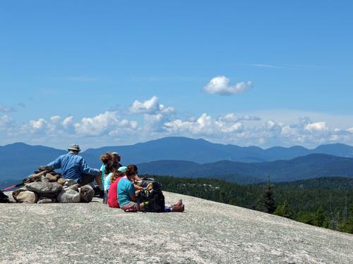 hikers enjoying lunch on the ledge on Dickey Mountain in New Hampshire